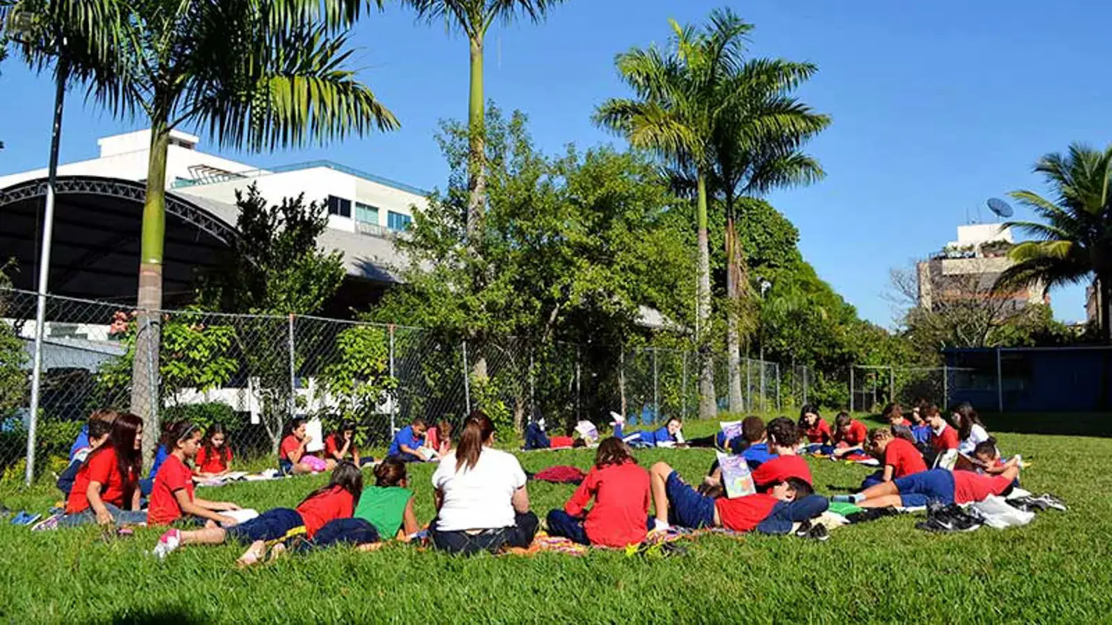 Alunos do Camões em roda de leitura no gramado da escola
